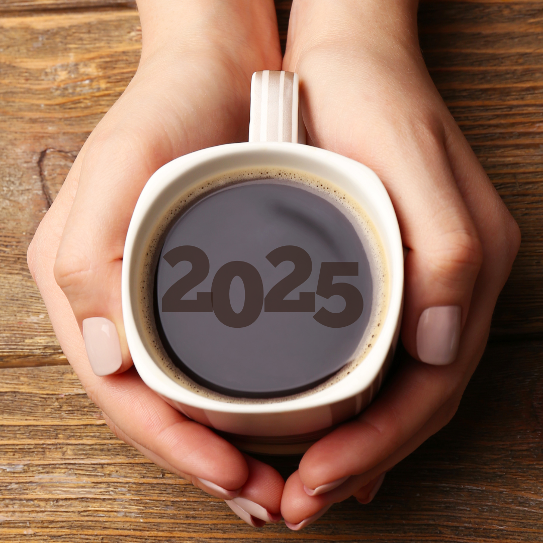 Hands holding a cup of premium Jamaican coffee with "2025" in the foam of the coffee