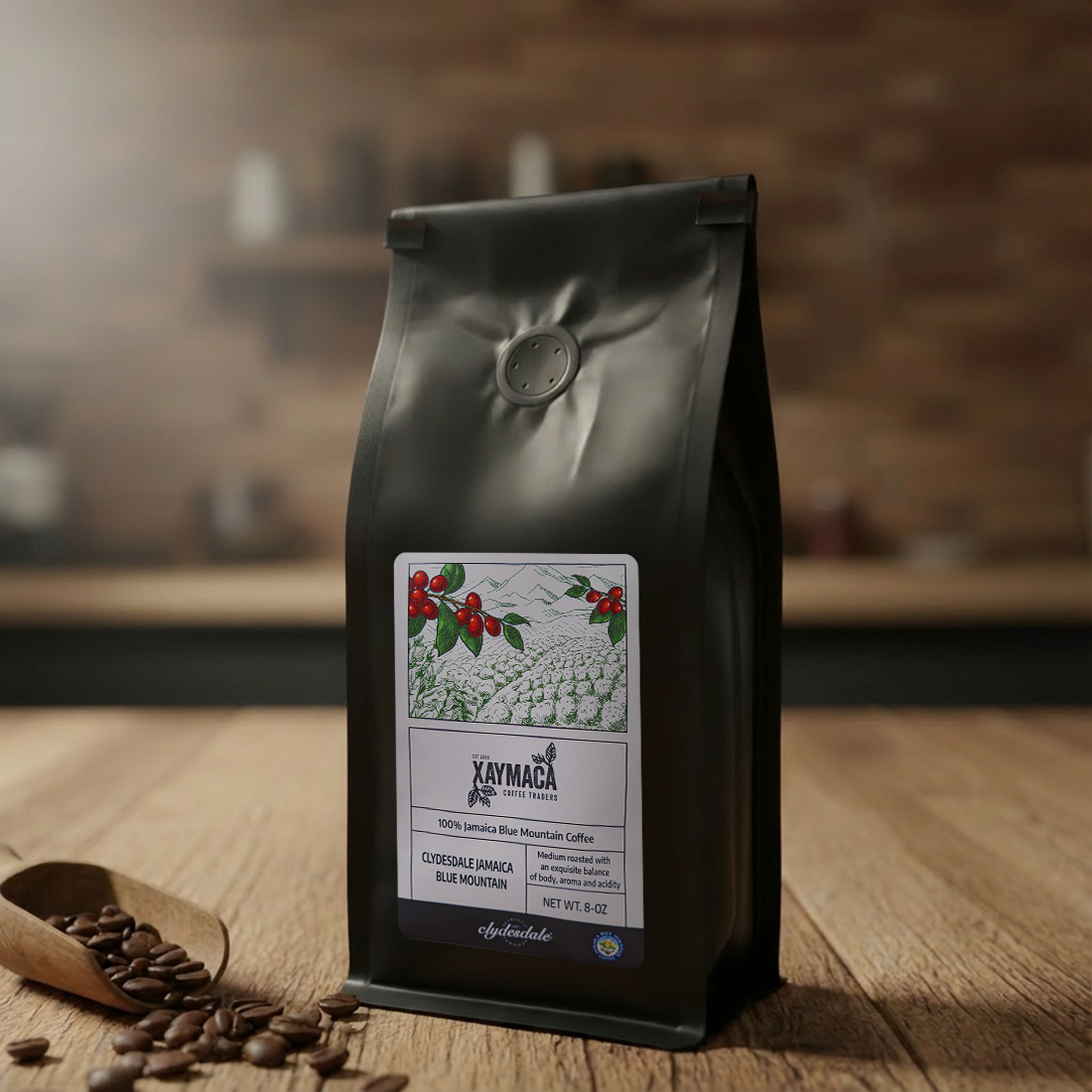 Black coffee bag with a label on a wooden surface, with coffee beans and a scoop in the foreground.