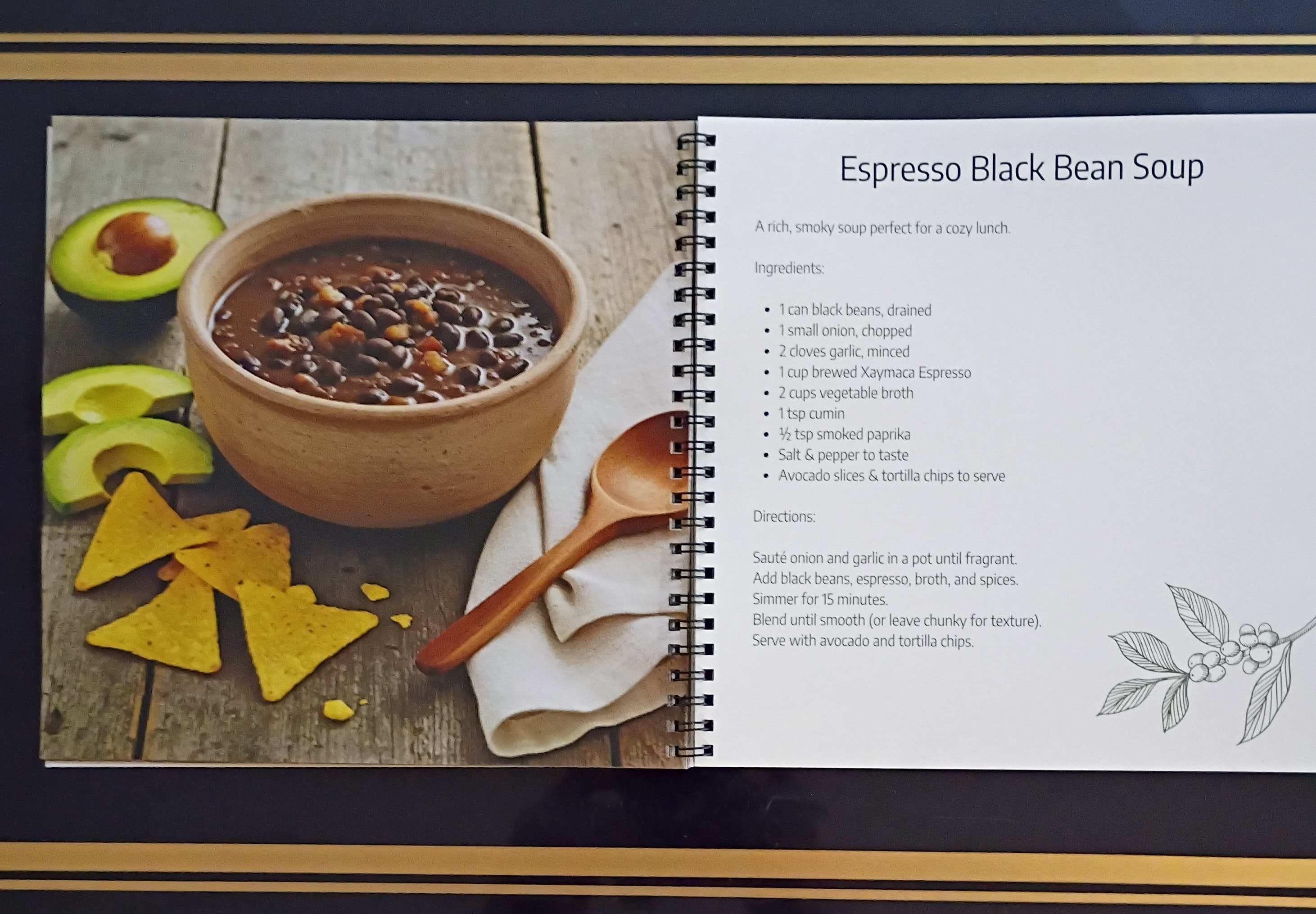 Xaymaca Coffee Traders Recipe book page for Espresso Black Bean Soup with a bowl of soup, tortilla chips, and avocado on a wooden surface.