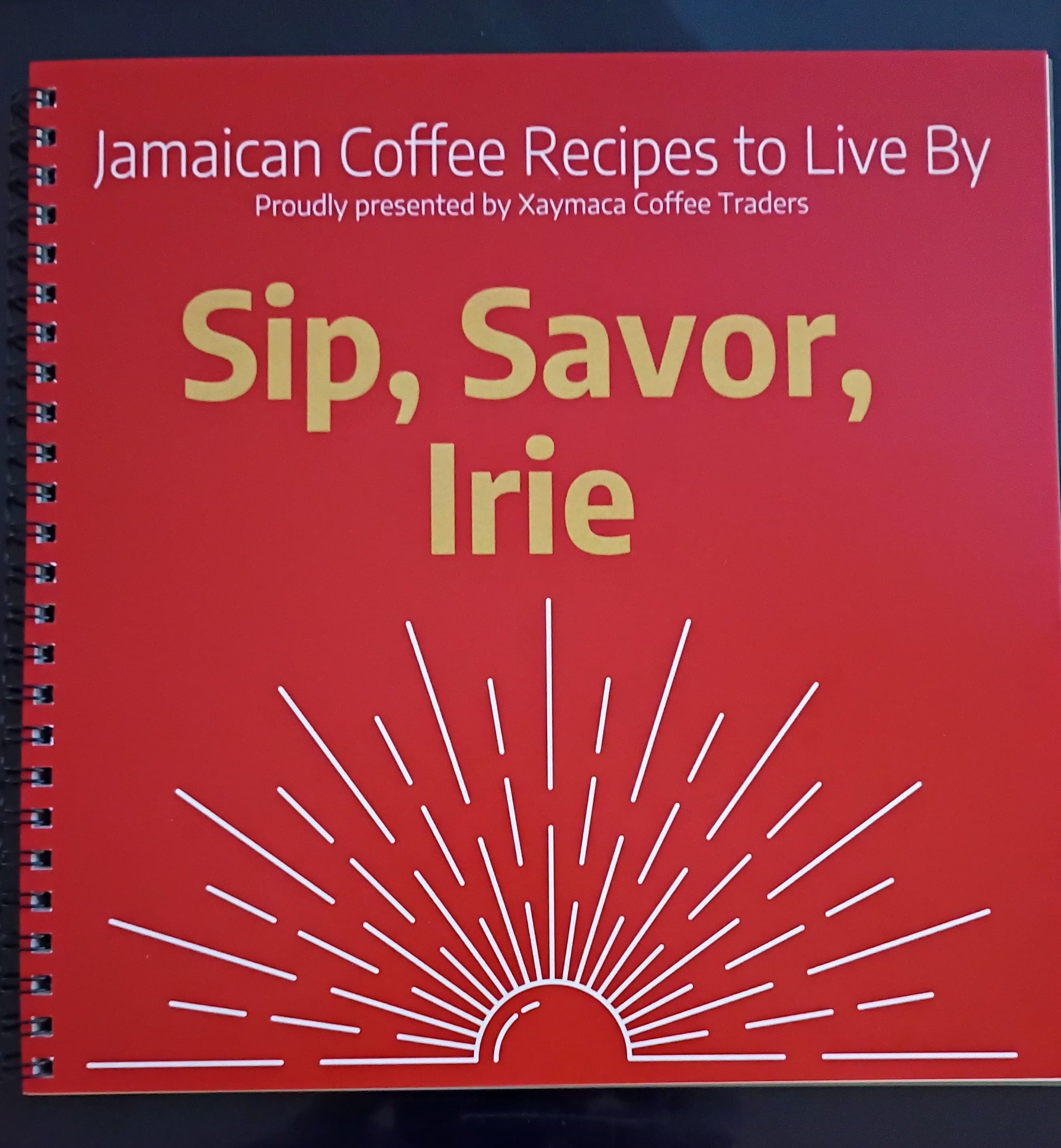 Book titled 'Jamaican Coffee Recipes to Live By' by Xaymaca Coffee Traders on a red cover with yellow text.